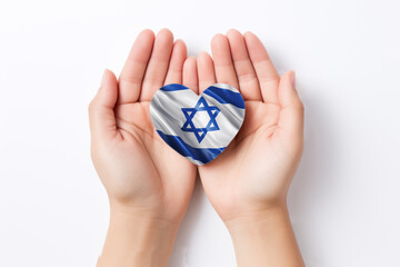 Hands holding Israel flag in heart shape on white background, top view