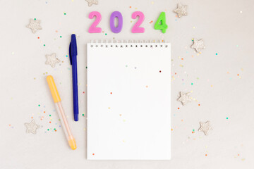 White sheet of notebook with pen on gray table. Concept planning, wish list for the new year. Christmas mockup for lettering, art drawing.
