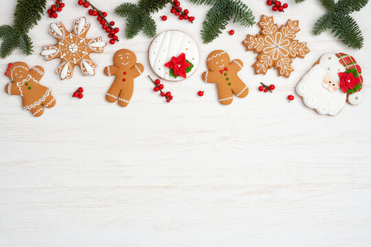 Christmas background with gigerbread cookies, red berries and fir branches