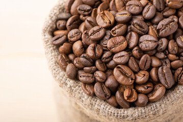 Close up of coffee beans in linen sack. Roasted aromatic coffee grain in bag made of linen fiber