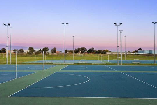 Dusk sky behind empty netball courts in sports park