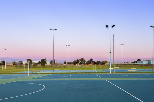 Dusk sky behind empty netball courts in sports park