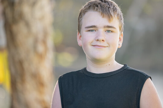 Fototapeta Portrait of pre-teen boy with wry smile in nature