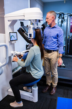 Physiotherapist working with client on physio equipment for treatment of back pain