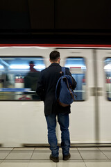 Young man standing in front of subway train
