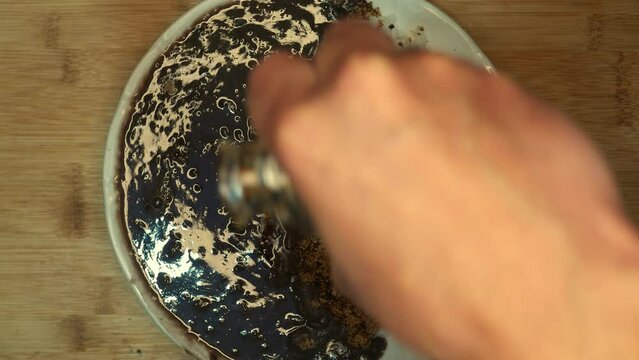 Slowly zooming away, POV: person pouring olive oil on beans. Feijoada on the table (bean stew). Plate of beans with rice and farofa (cooked cassava flour) on the table. White rice dish. Cooking day. 