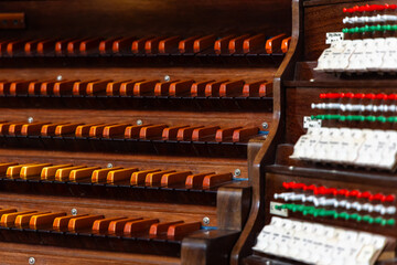 Wooden keyboard of an antique church pipe organ. The photo was taken in the semi-darkness of the...