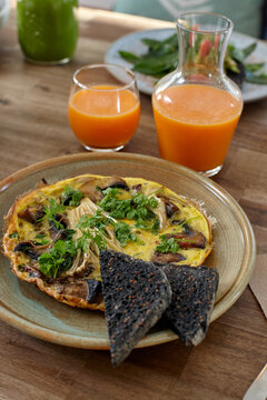 Healthy omelet dish and juice on wooden table