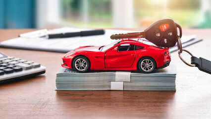 Red car on dollar banknotes for car loan or buying new car concept.