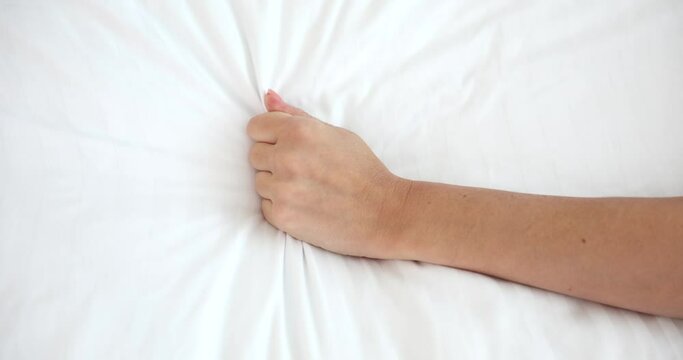 Woman hand pulling white sheets in lust and orgasm. Intimate life
