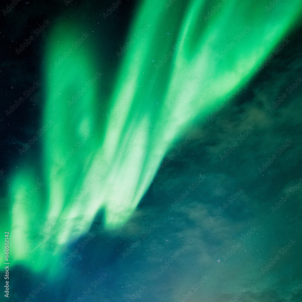 Wall mural bright and active aurora borealis or northern lights glowing in the night sky on arctic circle