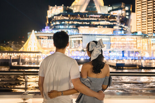 Young Asian Couple Embracing And Sightseeing With Light Show At Department Store During Cruise Ship On Deck