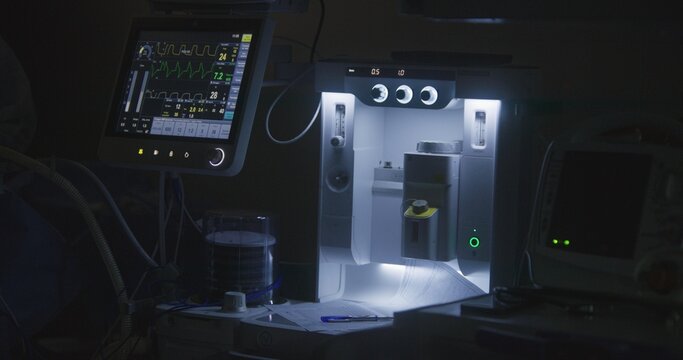 Close up shot of moving pulmoflator and monitor screen with displayed vital signs during surgery. Medical equipment in intensive care unit. Medics work in modern operating room. Emergency department.