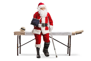 Sad santa claus with injured leg and arm sitting on a mat table