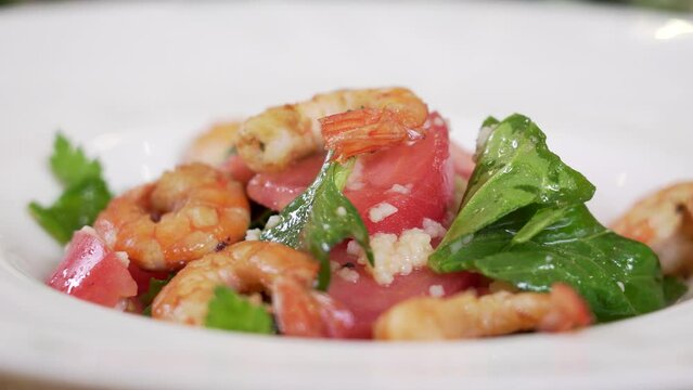 Serving fresh vegetable salad with cuscus and shrimps