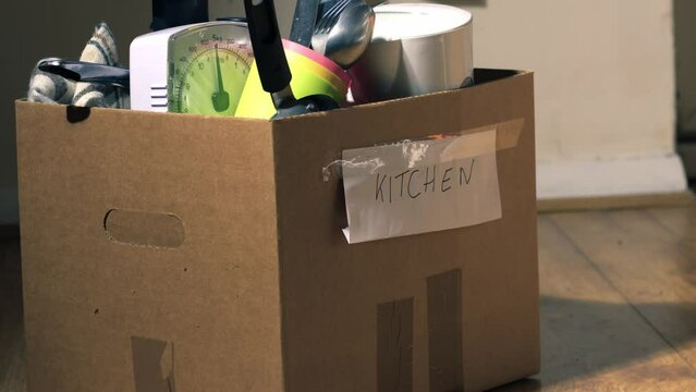 Moving home with kitchen goods packed in a box
