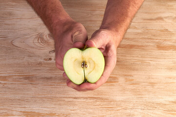 Men's hands are peels fresh apple with knife