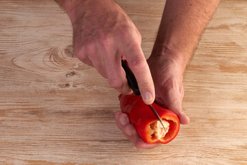 Men's hands are catting fresh pepper