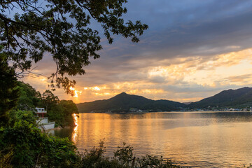 Orange sunset glow reflects off calm coastal waters on Shodo Island