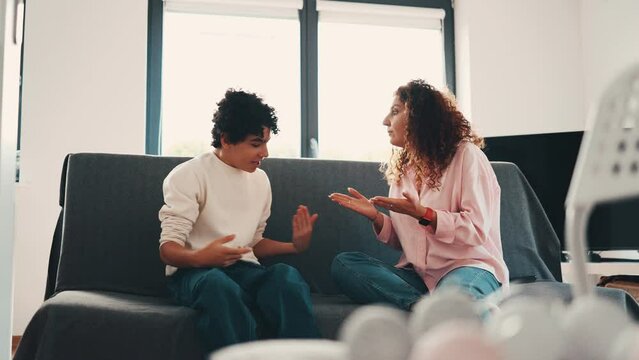Mother talking with her teenage son at home
