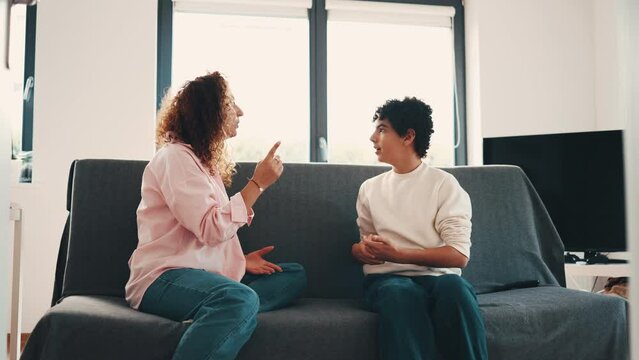 Mother talking with her teenage son at home
