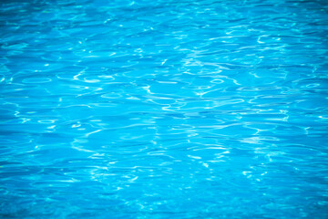 Water and air bubbles over blue background,sea wave ,Bokeh light background in the pool,Hotel swimming pool with sunny reflections.