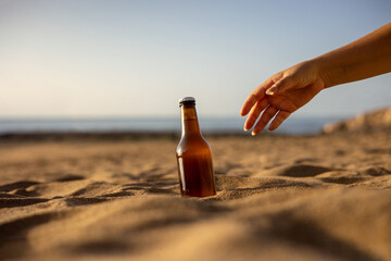 Deux bières sur la plage, une main tendue. - obrazy, fototapety, plakaty