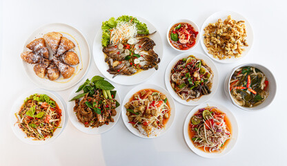 Top view Thai food on the table: Somtum - Spicy Papaya Salad, Grilled pork neck, Larb moo - Spicy...