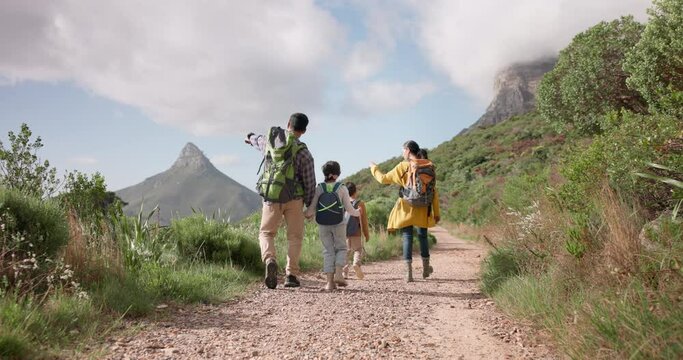 Family hiking, nature and walking in forest for fitness and bonding, parents and kids holding hands with back view. Sightseeing, travel and adventure with man, woman and children outdoor in mountains