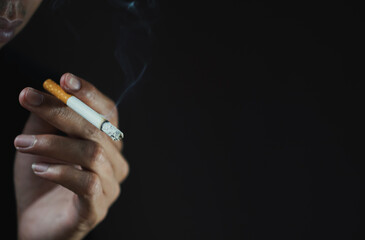 A man smoking cigarette in dark room