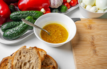 Dressing sauce for vegetable salad in a separate bowl.