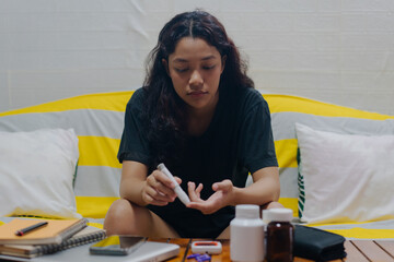 Teen takes a blood sample for diabetes with lancet pen. Health, medicine and diabetic concept.