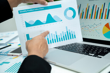 Asian accountant working and analyzing financial reports project accounting with chart graph in...