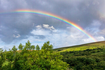 A rainbow over the slopes of Dunkery Beacon on Exmoor National Park from Cloutsham, Somerset, England UK