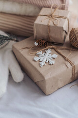Fototapeta na wymiar Christmas gifts wrapped in craft paper with twine and snowflake on white background