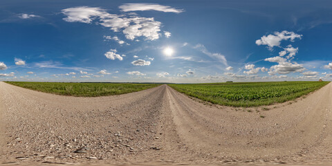 360 hdri panorama on gravel road with marks from car or tractor tires with clouds on blue sky in equirectangular spherical  seamless projection, skydome replacement in drone panoramas