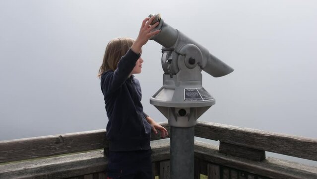a boy with binoculars on the mountain