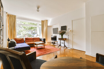 a living room with couches, chairs and a flat screen tv on the wall in the corner of the room