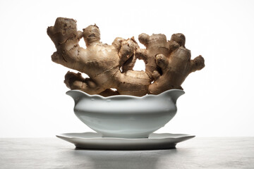 Ginger root in a dishes on a white background. Healthy Food concept. Ginger. Selective focus