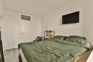 a bedroom with a bed and television on the wall above it, in an apartment near meerpling