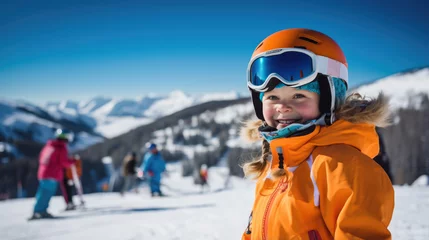 Foto op Canvas Portrait of a kid skier in helmet and winter clothes on the background of snow-covered mountain slope © MP Studio