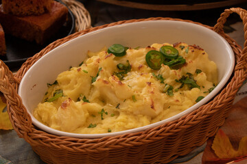 Vegan mashed poatoes as part of a plant-based Thanksgiving table setting, served in vintage ceramic and  wicker woven basket