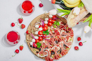 Picnic food concept. Basket with wine and baguette, set of snacks on skewers. Meat, cheese
