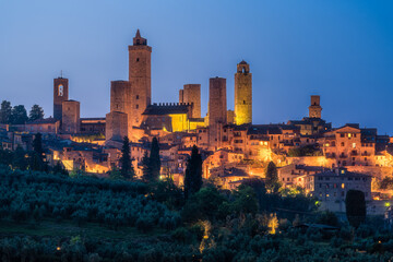 Naklejka premium The marvelous city of San Giminiano with all its towers illuminated on a summer evening. Province of Siena, Tuscany, Italy.