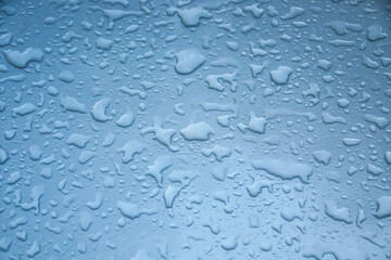 Drops of water on the hood of a car and on the glass as an abstract background