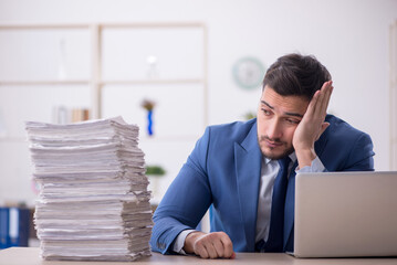 Young male employee and too much work in the office