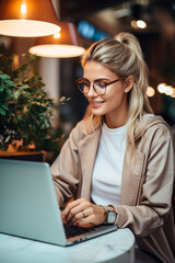 Young woman smiling working on her laptop at cafe bar