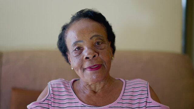Close-up of a black Senior Brazilian woman speaking to camera in POV video conference. Webcam point of view of an older person talking