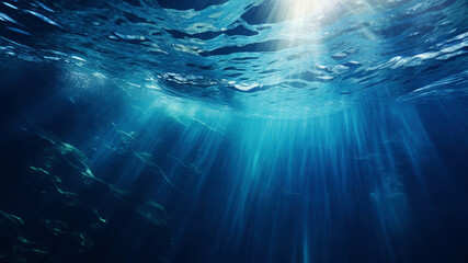 Sun shining light in blue clearly deep water, sunbeams illuminate the blue underwater sea scene,...