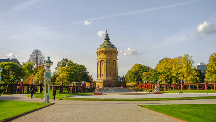 Mannheim, Germany. Panoramic view over old city water tower at Friedrich square in sunset golden Autumn colors. Cityscape in the historical downtown at sunny day and milky blue sky.
